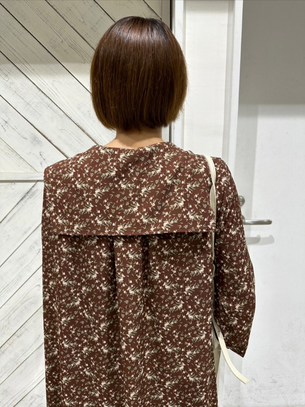 ブラウン系のワンピース、ブラウン系のその他シューズ、ホワイト系のショルダーバッグを着用したレディースの夏コーディネートの2枚目の写真