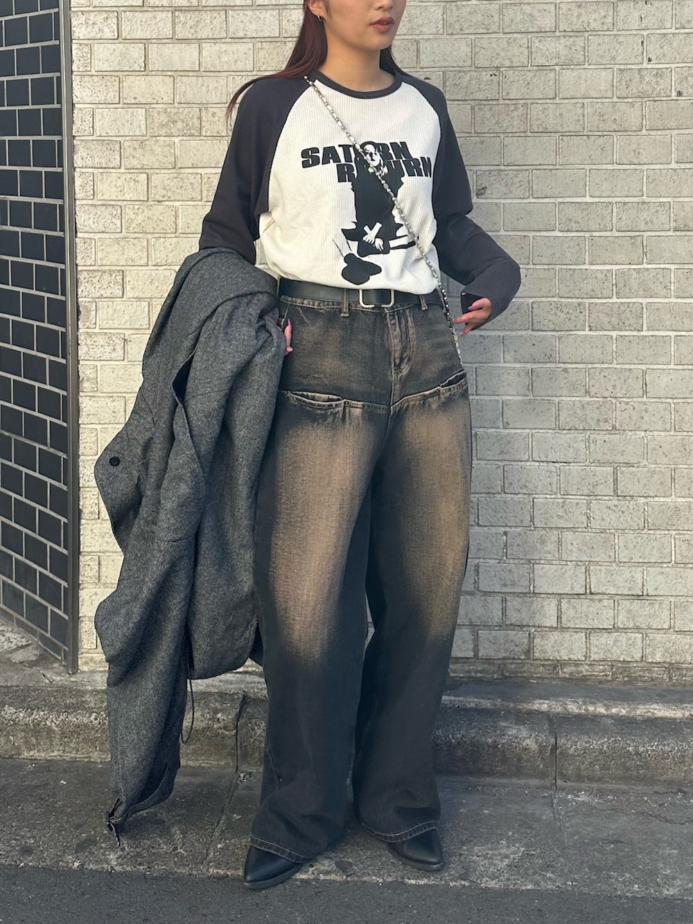 グレー系のTシャツ/カットソー、ブルー系のデニムパンツ、シルバー系のショルダーバッグを着用したレディースの冬コーディネートの2枚目の写真