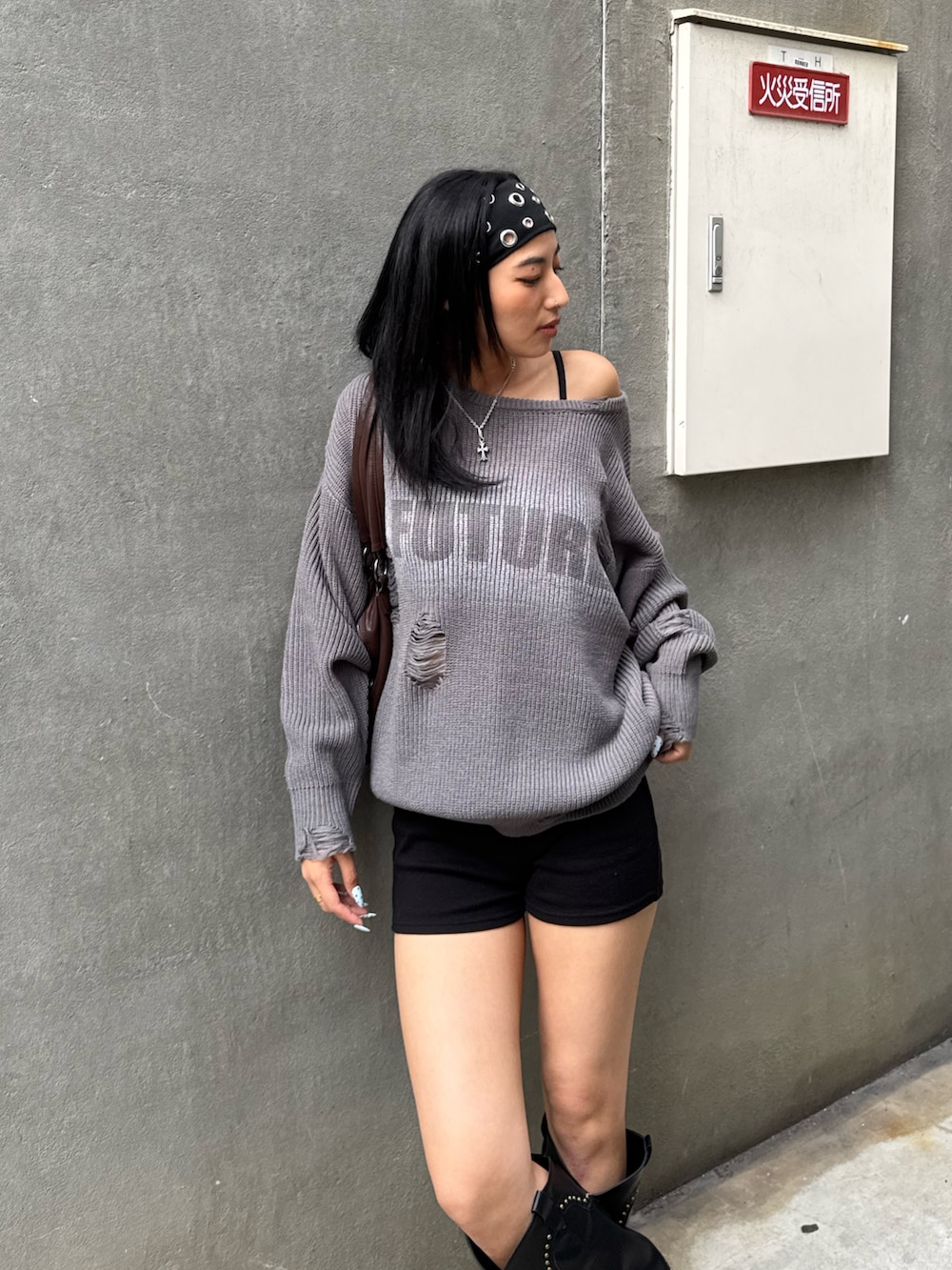 グレー系のニット/セーター、ブラック系のパンツ、ブラック系のブーツを着用したレディースの秋コーディネートの2枚目の写真