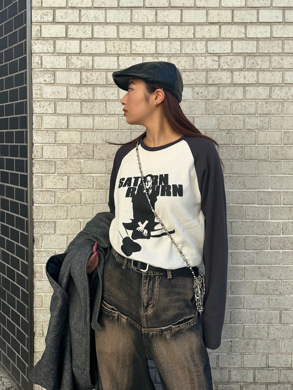 グレー系のTシャツ/カットソー、ブルー系のデニムパンツ、シルバー系のショルダーバッグを着用したレディースの冬コーディネートの3枚目の写真