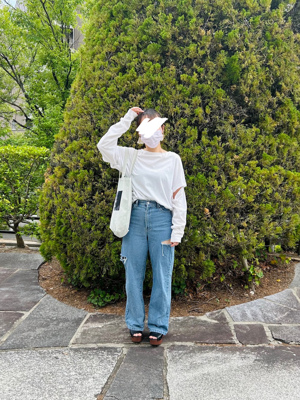 ブルー系のデニムパンツ、ホワイト系のTシャツ/カットソー、ホワイト系のトートバッグを着用したレディースの春コーディネートの3枚目の写真