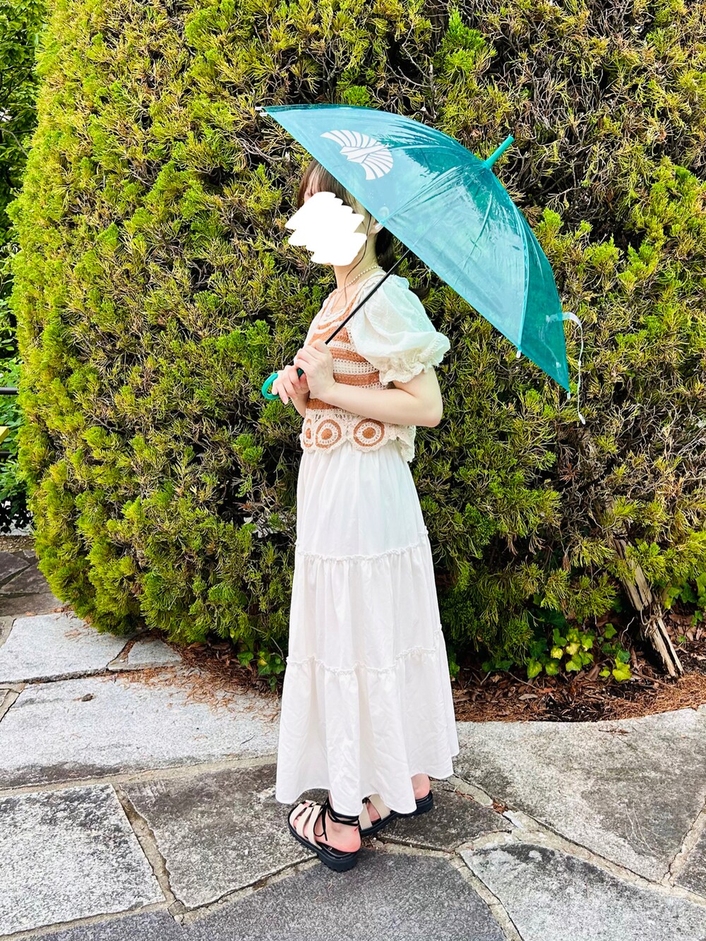 ホワイト系のサンダル、ホワイト系のスカート、オレンジ系のTシャツ/カットソーを着用したレディースの夏コーディネートの5枚目の写真