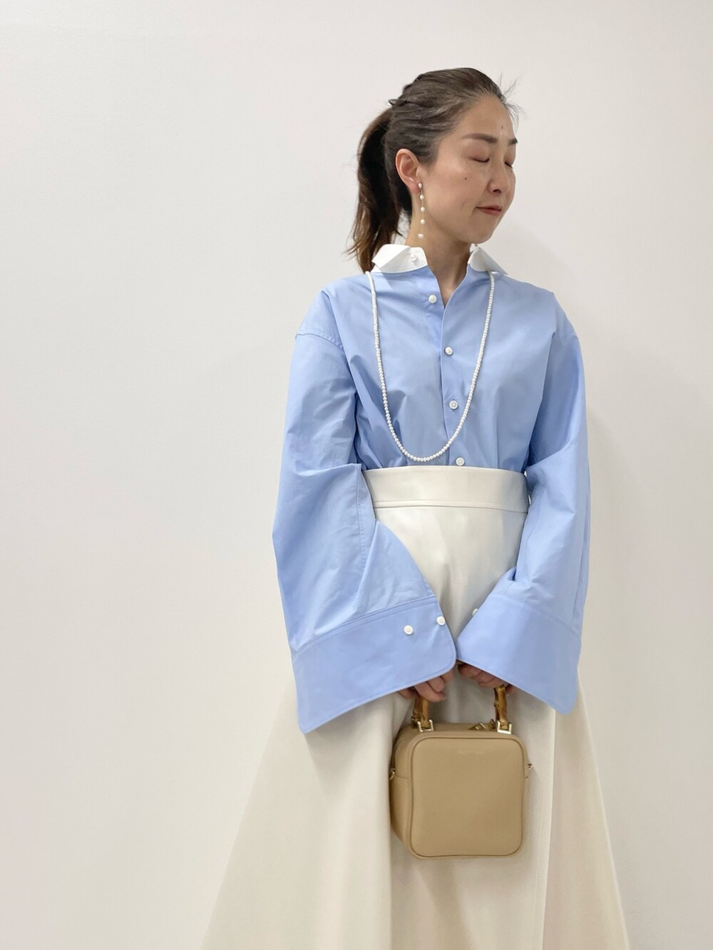 ブルー系のシャツ/ブラウス、ホワイト系のスカート、ホワイト系のネックレスを着用したレディースの冬コーディネートの7枚目の写真