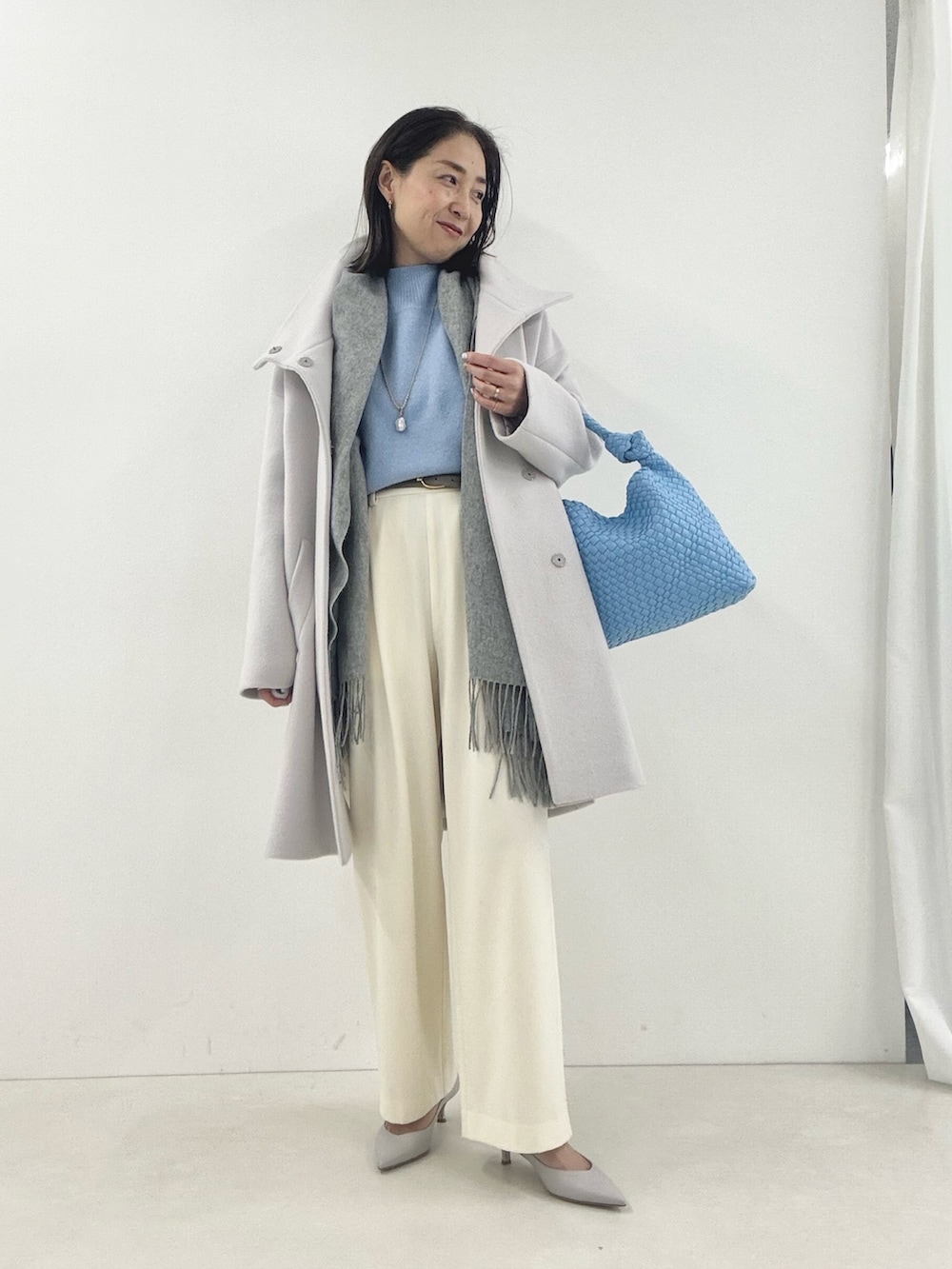 ホワイト系のその他パンツ、グレー系のパンプス、ベージュ系のその他アウターを着用したレディースの冬コーディネートの2枚目の写真