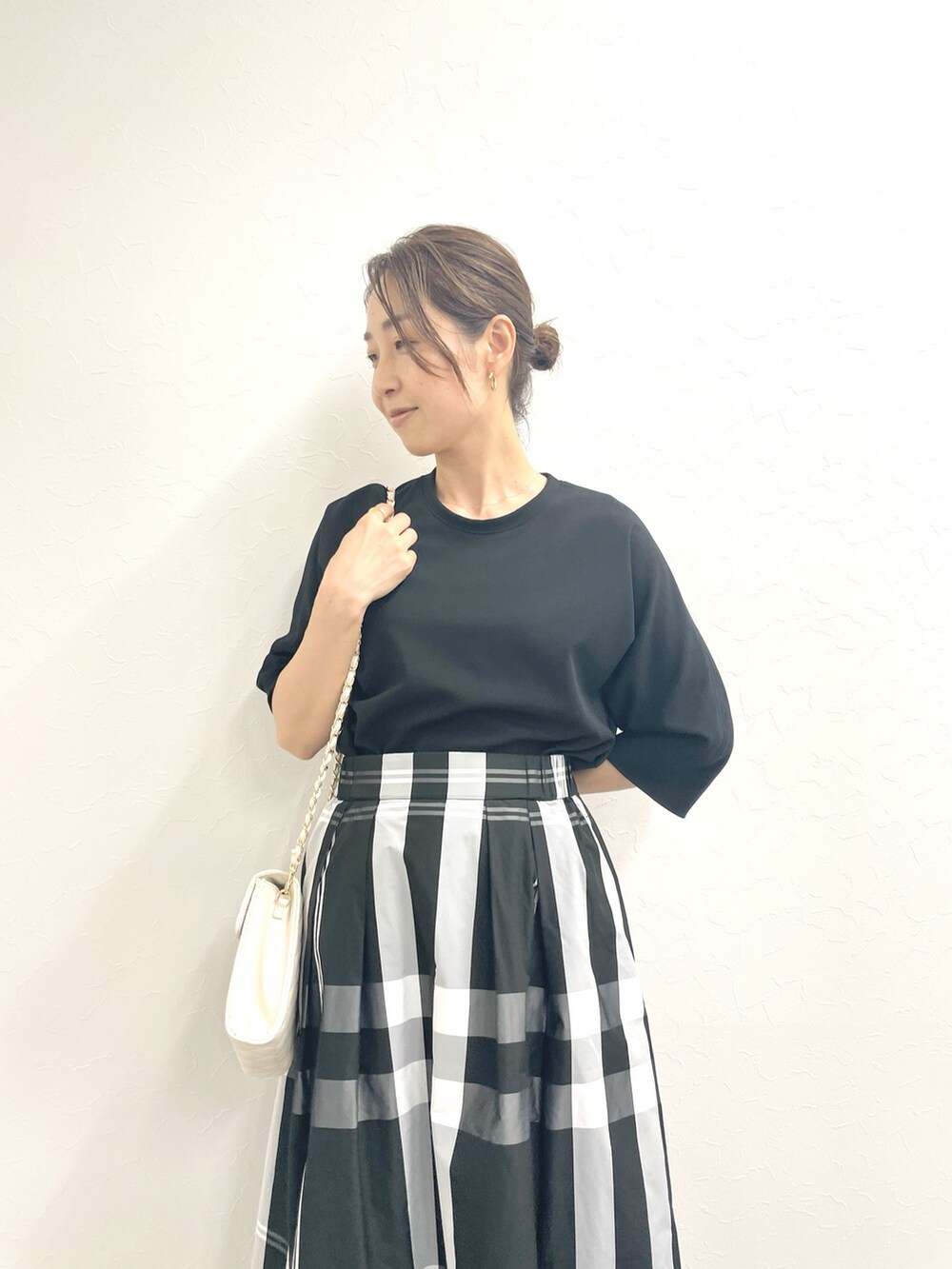 ブラック系のTシャツ/カットソー、ホワイト系のショルダーバッグ、ブラック系のスカートを着用したレディースの春コーディネートの9枚目の写真