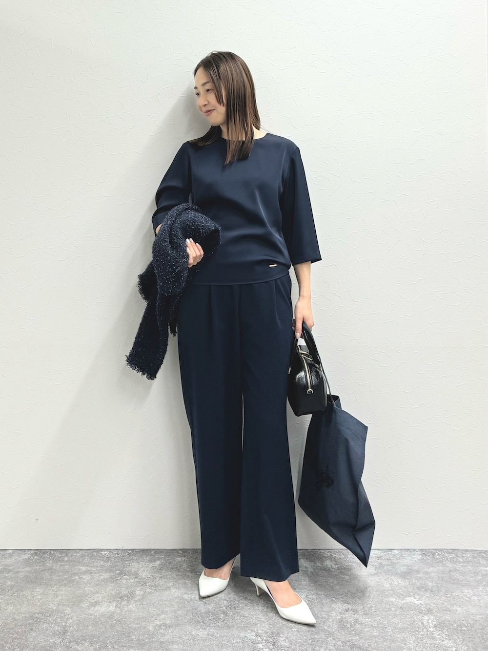 ブルー系のノーカラージャケット、ブルー系のシャツ/ブラウス、ブラック系のバッグを着用したレディースの秋コーディネートの3枚目の写真