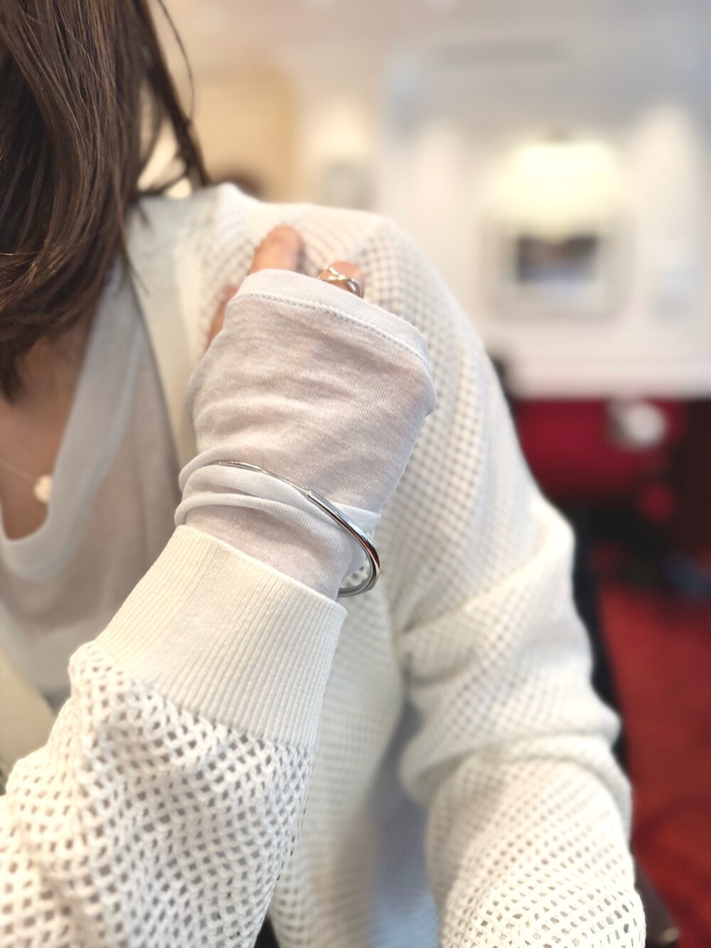 ブルー系のデニムパンツ、ブラウン系のショルダーバッグ、ホワイト系のカーディガン/ボレロを着用したレディースの春コーディネートの9枚目の写真