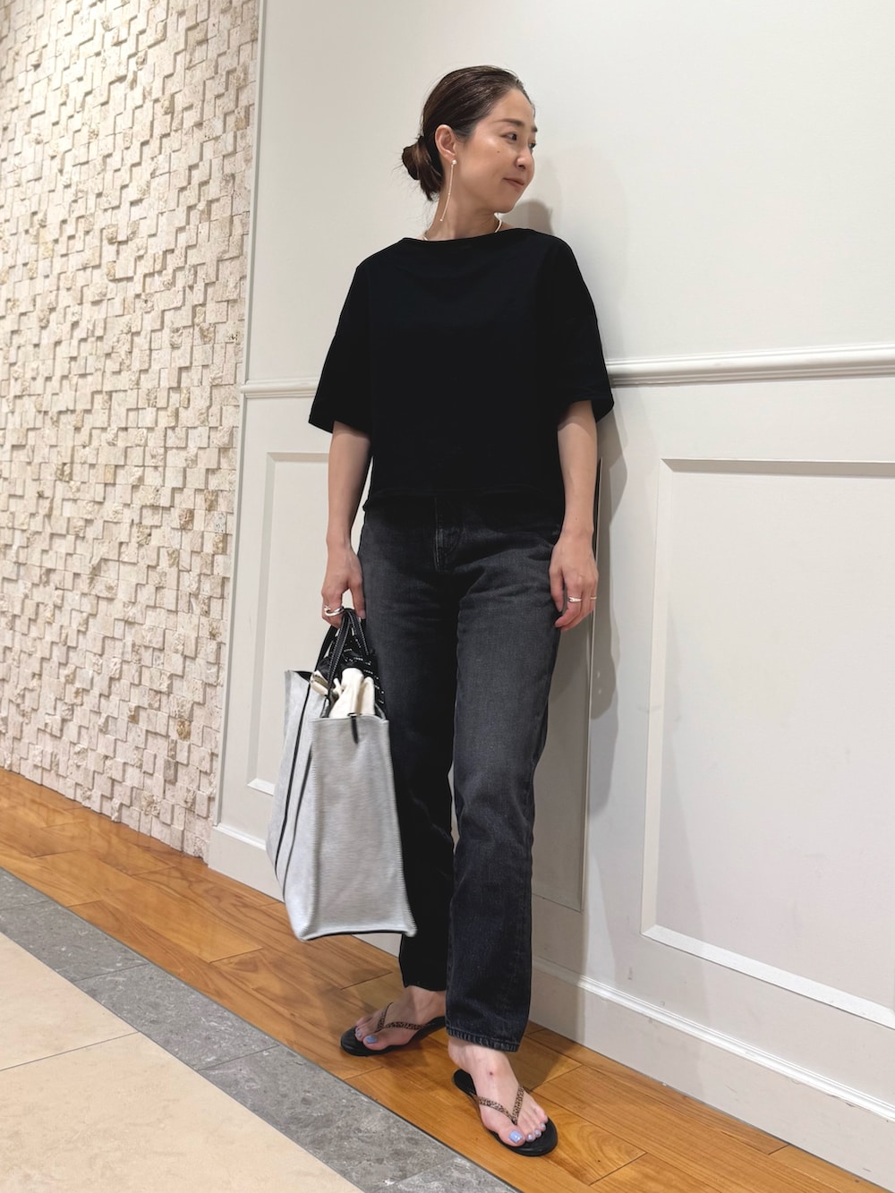 ブラック系のTシャツ/カットソー、ホワイト系のショルダーバッグ、ブラック系のデニムパンツを着用したレディースの夏コーディネートの3枚目の写真