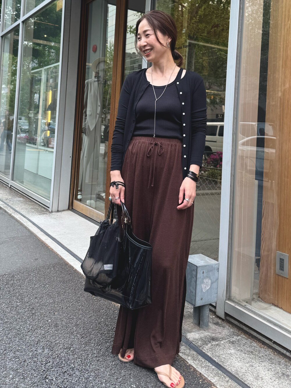 ブラウン系のその他パンツ、ブラック系のカーディガン/ボレロ、シルバー系のネックレスを着用したレディースの夏コーディネートの7枚目の写真