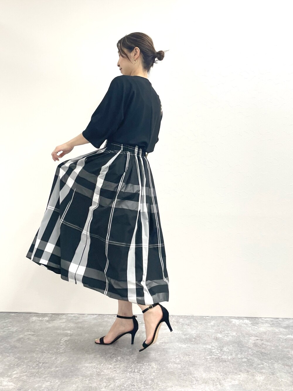 ブラック系のTシャツ/カットソー、ホワイト系のショルダーバッグ、ブラック系のスカートを着用したレディースの春コーディネートの7枚目の写真