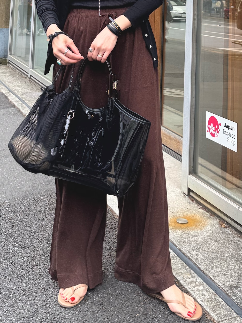 ブラウン系のその他パンツ、ブラック系のカーディガン/ボレロ、シルバー系のネックレスを着用したレディースの夏コーディネートの2枚目の写真