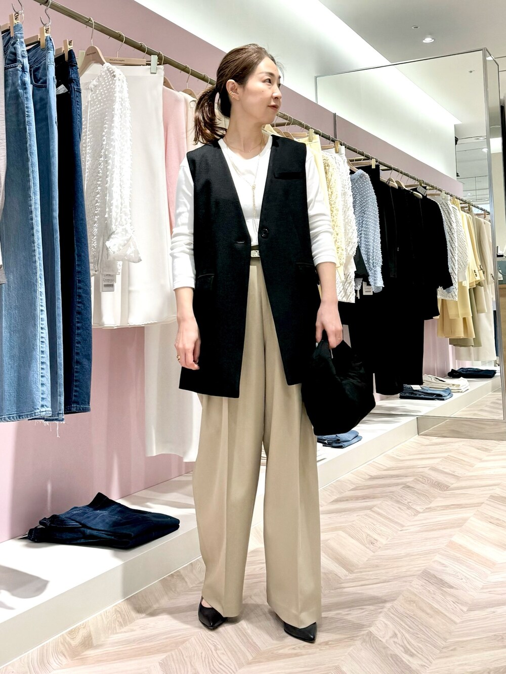 グリーン系のその他パンツ、ホワイト系のTシャツ/カットソー、ブラック系のベストを着用したレディースの春コーディネートの3枚目の写真