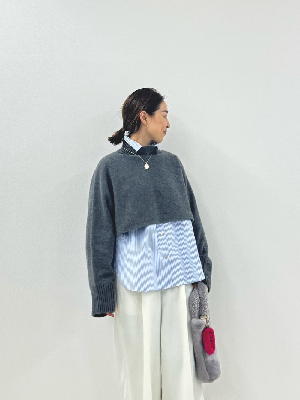 グレー系のニット/セーター、ブルー系のシャツ/ブラウス、ホワイト系のその他パンツを着用したレディースの秋コーディネートの2枚目の写真