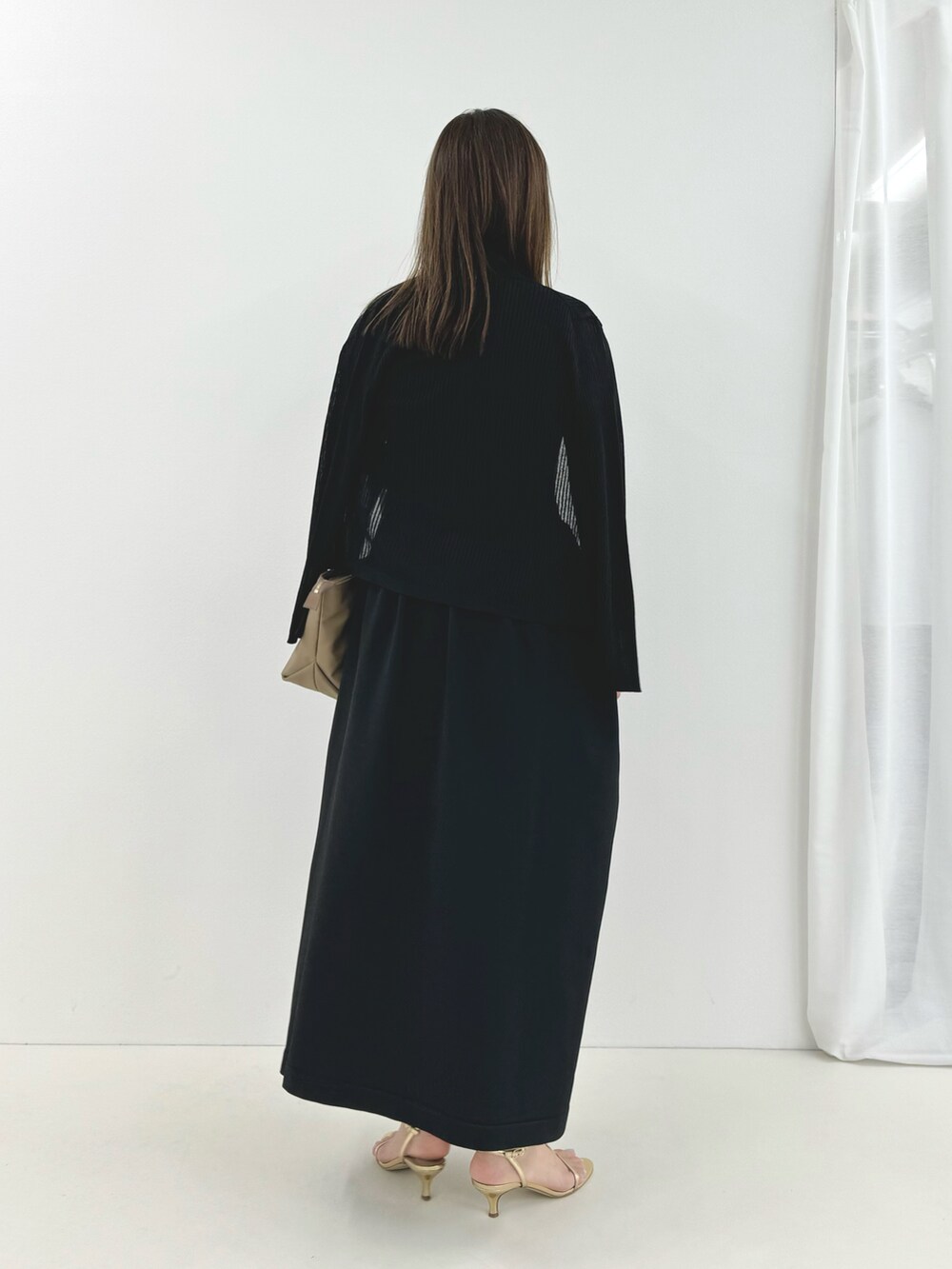 ブラック系のワンピース、ベージュ系のトートバッグ、ブラック系のカーディガン/ボレロを着用したレディースの夏コーディネートの3枚目の写真