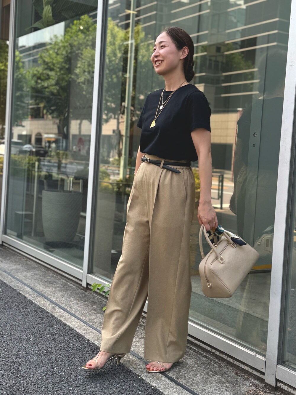 イエロー系のその他パンツ、ブラック系のTシャツ/カットソー、ベージュ系のショルダーバッグを着用したレディースの夏コーディネートの4枚目の写真