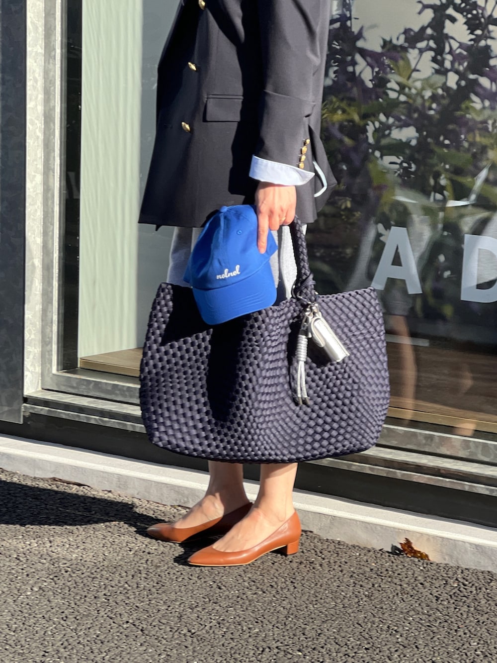 ブルー系のテーラードジャケット、ブルー系のトートバッグ、グレー系のスウェットパンツを着用したレディースの春コーディネートの6枚目の写真