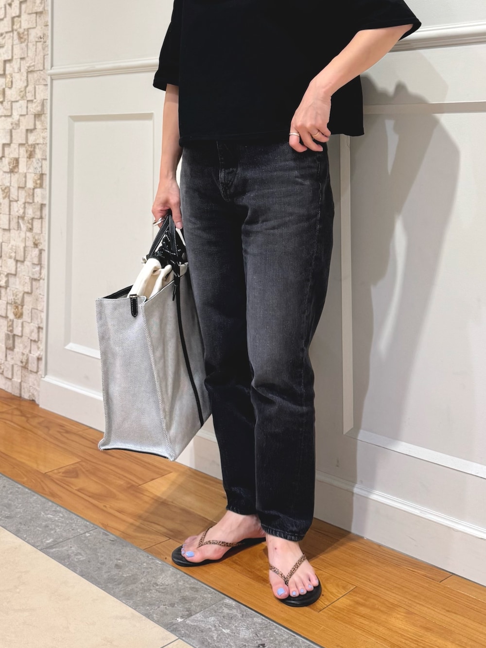 ブラック系のTシャツ/カットソー、ホワイト系のショルダーバッグ、ブラック系のデニムパンツを着用したレディースの夏コーディネートの2枚目の写真