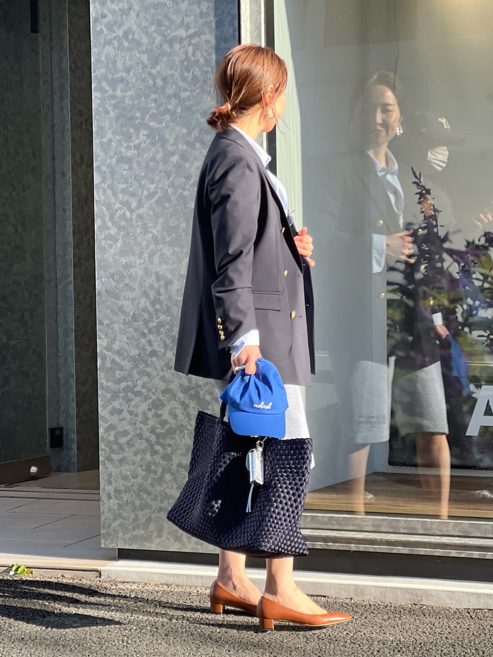 ブルー系のテーラードジャケット、ブルー系のトートバッグ、グレー系のスウェットパンツを着用したレディースの春コーディネートの7枚目の写真