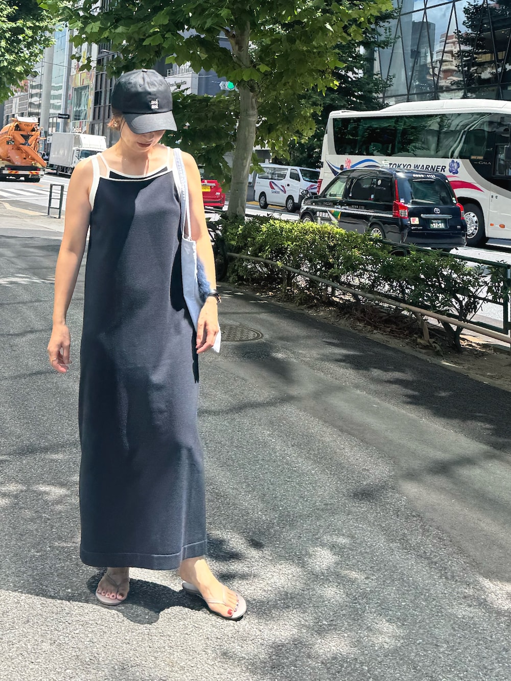 ブルー系のワンピース、ベージュ系のトートバッグ、ブラック系のキャミソールを着用したレディースの秋コーディネートの2枚目の写真