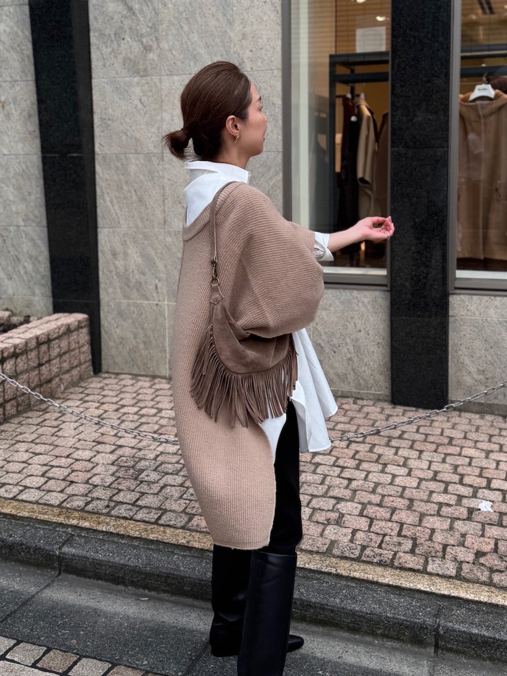 ベージュ系のニット/セーター、ホワイト系のシャツ/ブラウス、ベージュ系のショルダーバッグを着用したレディースの夏コーディネートの8枚目の写真
