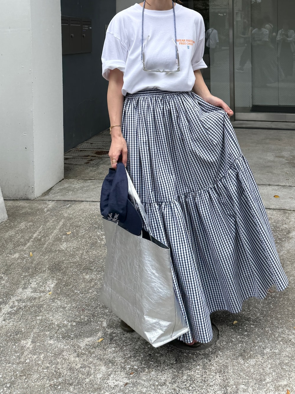 ホワイト系のTシャツ/カットソー、ブルー系のスカート、ブルー系のキャップを着用したレディースの夏コーディネートの9枚目の写真