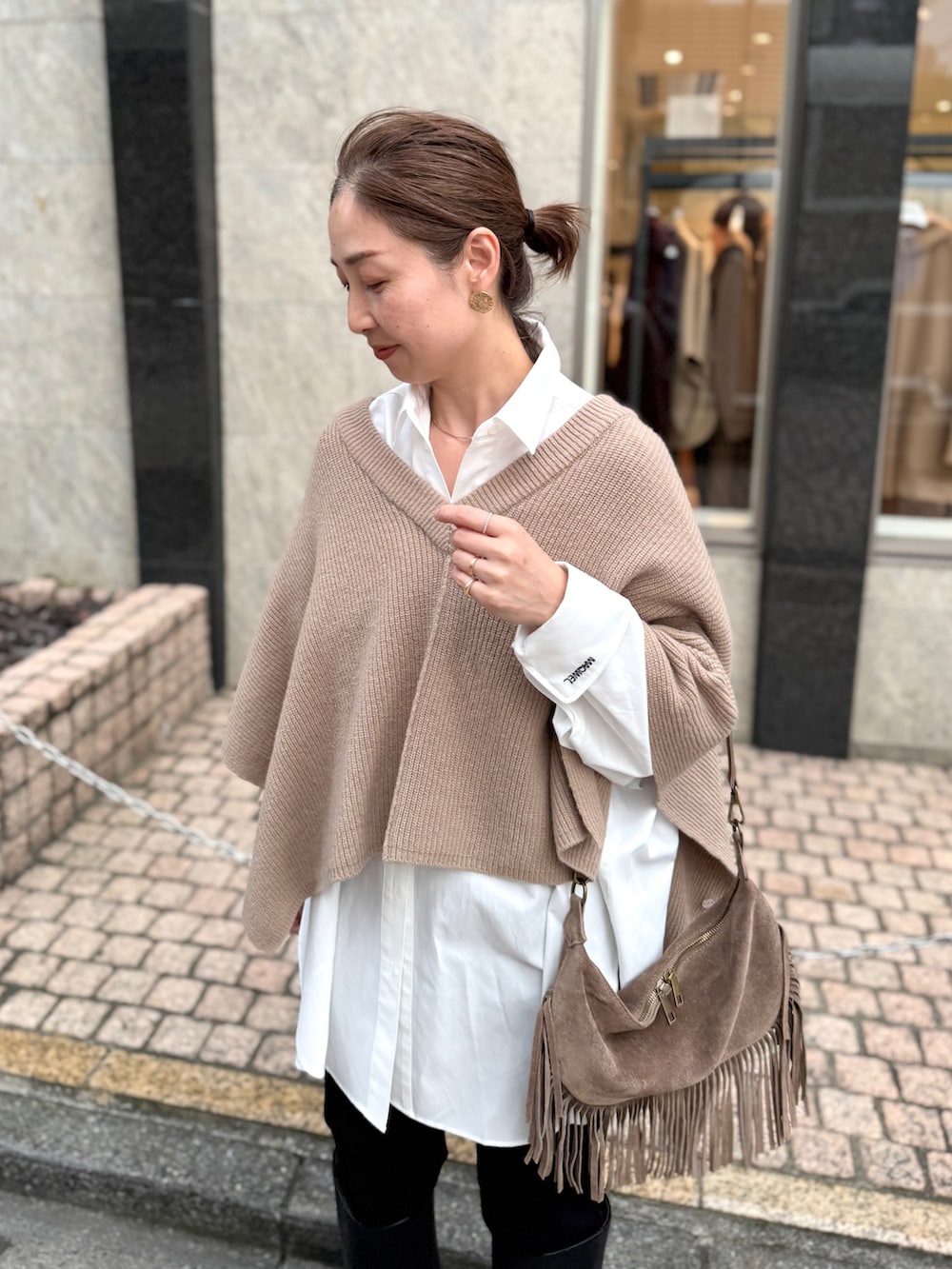 ベージュ系のニット/セーター、ホワイト系のシャツ/ブラウス、ベージュ系のショルダーバッグを着用したレディースの夏コーディネートの7枚目の写真