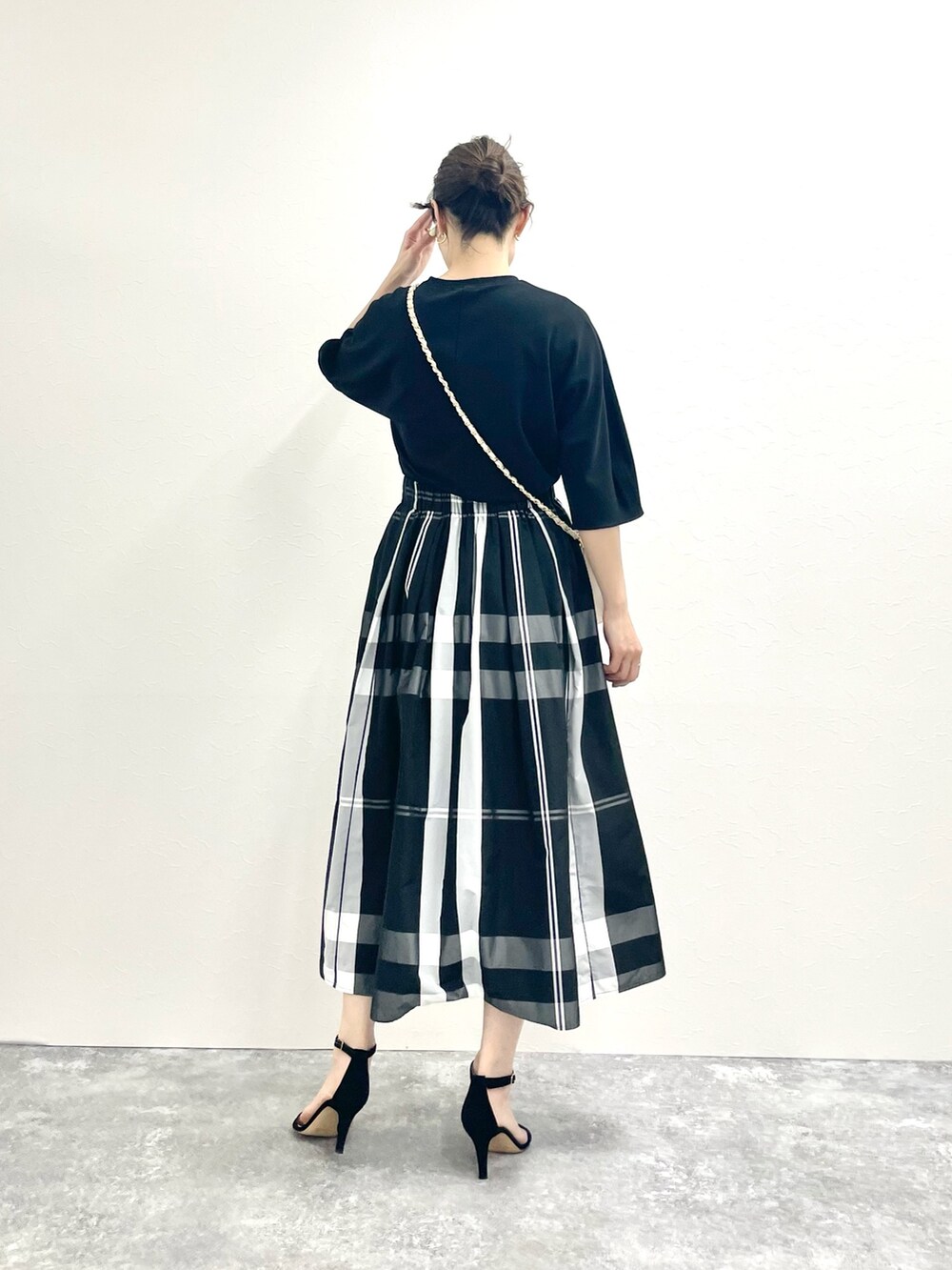 ブラック系のTシャツ/カットソー、ホワイト系のショルダーバッグ、ブラック系のスカートを着用したレディースの春コーディネートの4枚目の写真