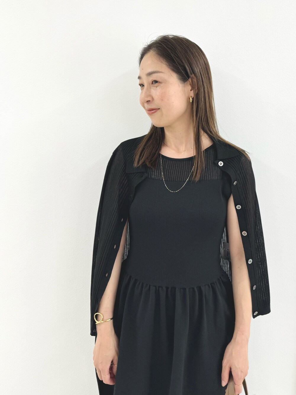 ブラック系のワンピース、ベージュ系のトートバッグ、ブラック系のカーディガン/ボレロを着用したレディースの夏コーディネートの2枚目の写真