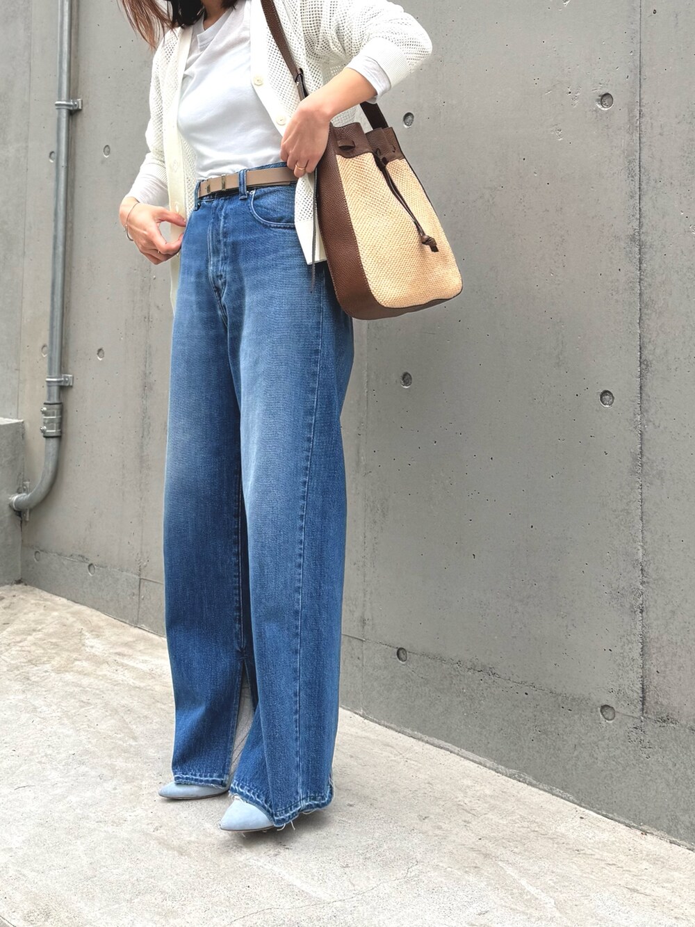 ブルー系のデニムパンツ、ブラウン系のショルダーバッグ、ホワイト系のカーディガン/ボレロを着用したレディースの春コーディネートの2枚目の写真