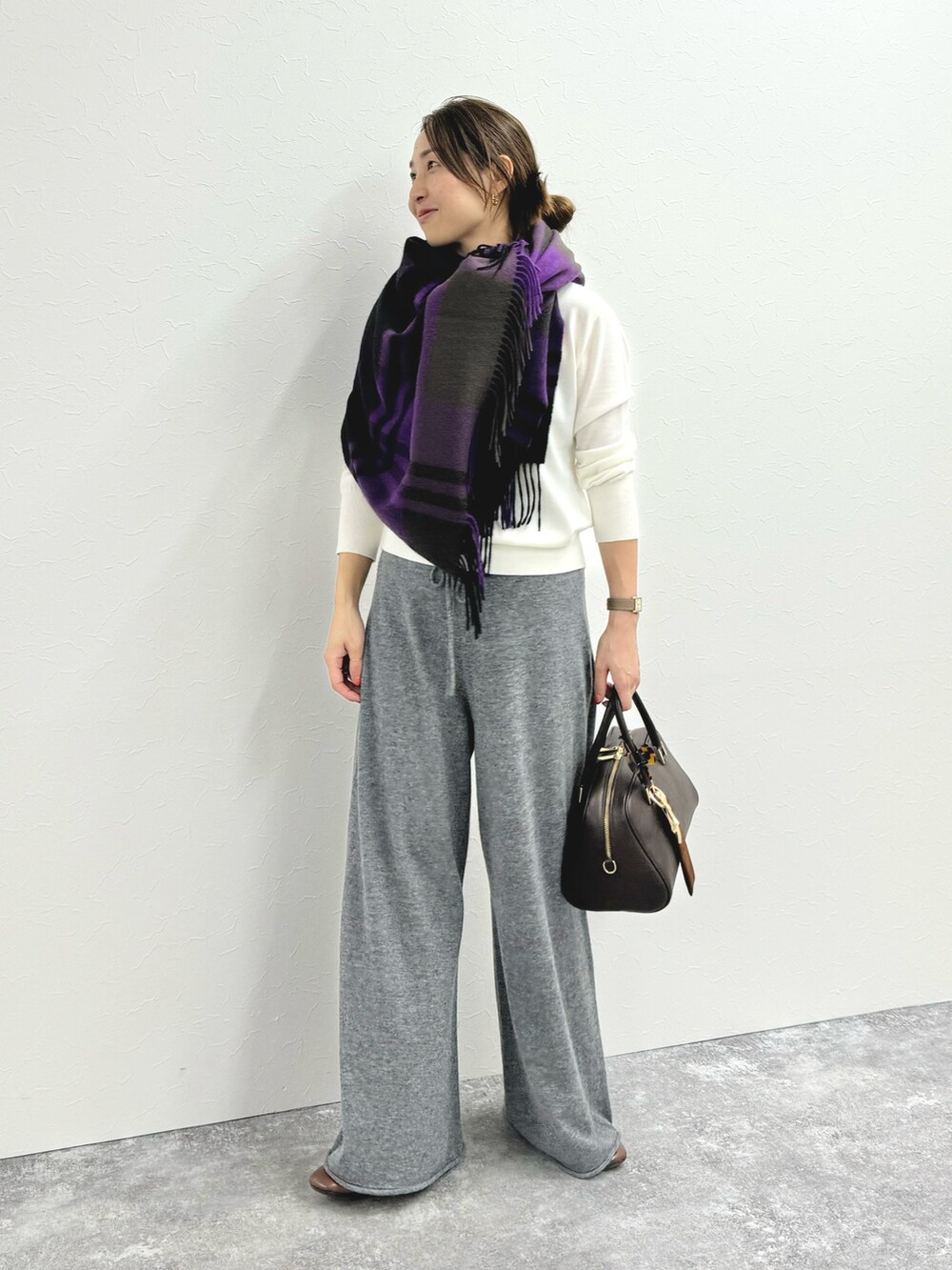 グレー系のその他パンツ、ブラウン系のショルダーバッグ、ホワイト系のニット/セーターを着用したレディースの秋コーディネートの2枚目の写真