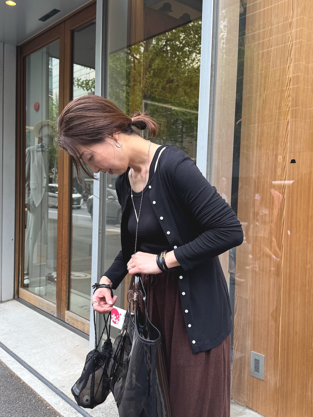 ブラウン系のその他パンツ、ブラック系のカーディガン/ボレロ、シルバー系のネックレスを着用したレディースの夏コーディネートの6枚目の写真