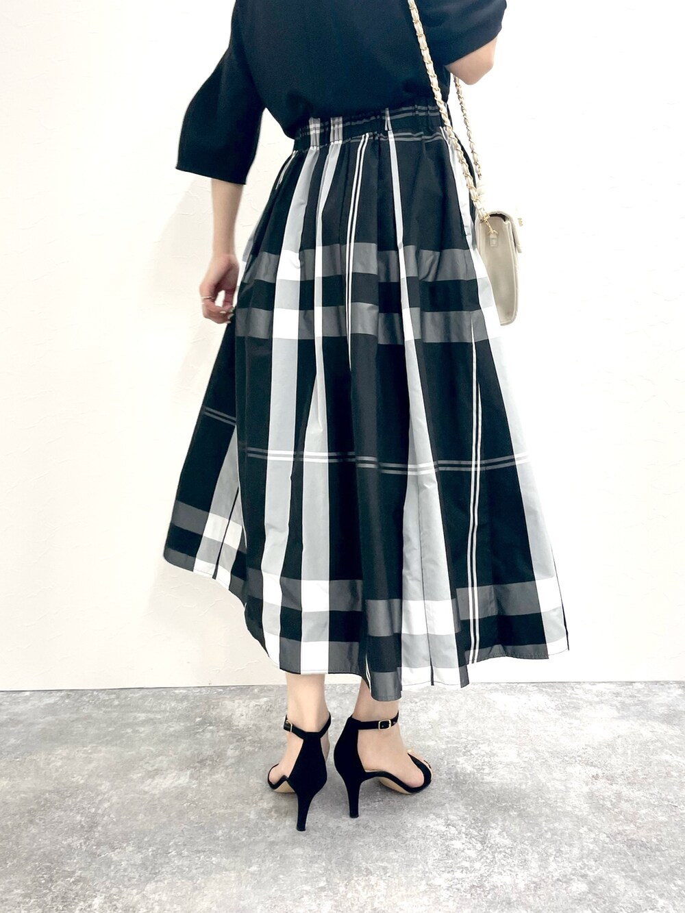 ブラック系のTシャツ/カットソー、ホワイト系のショルダーバッグ、ブラック系のスカートを着用したレディースの春コーディネートの8枚目の写真