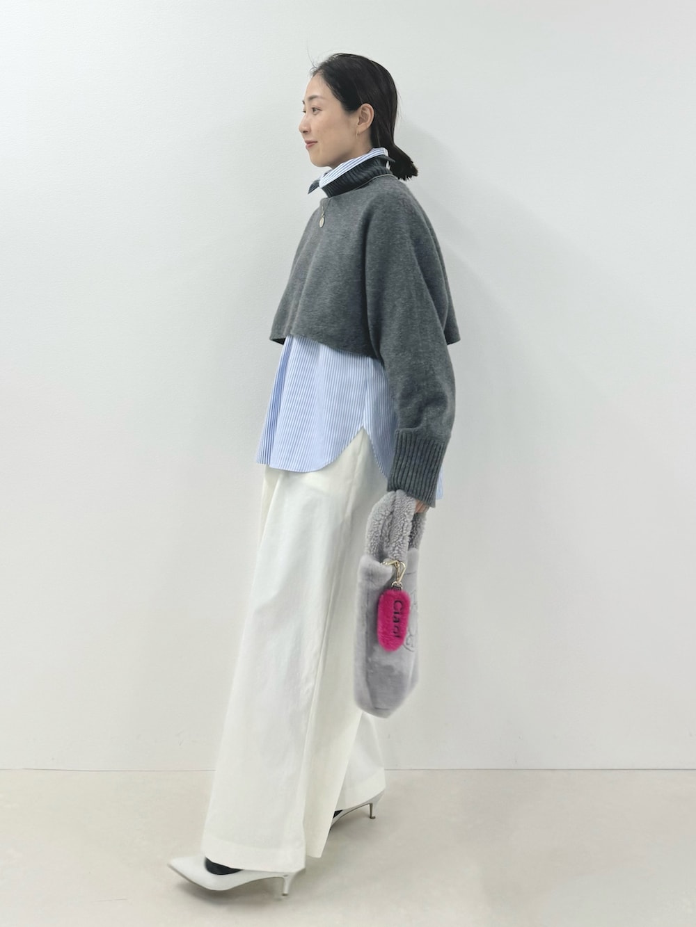 グレー系のニット/セーター、ブルー系のシャツ/ブラウス、ホワイト系のその他パンツを着用したレディースの秋コーディネートの4枚目の写真