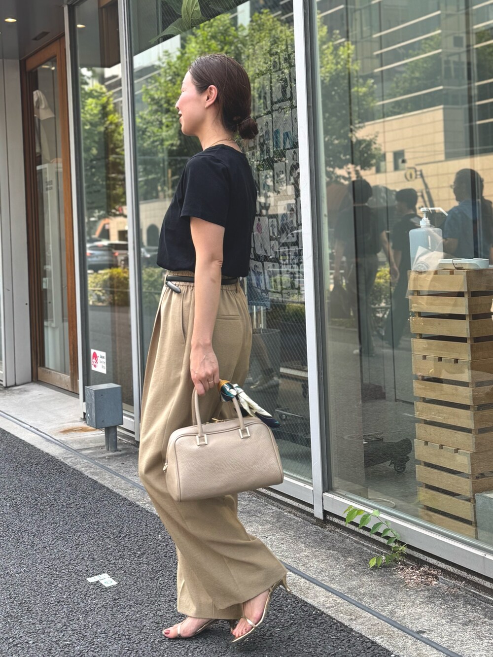 イエロー系のその他パンツ、ブラック系のTシャツ/カットソー、ベージュ系のショルダーバッグを着用したレディースの夏コーディネートの2枚目の写真