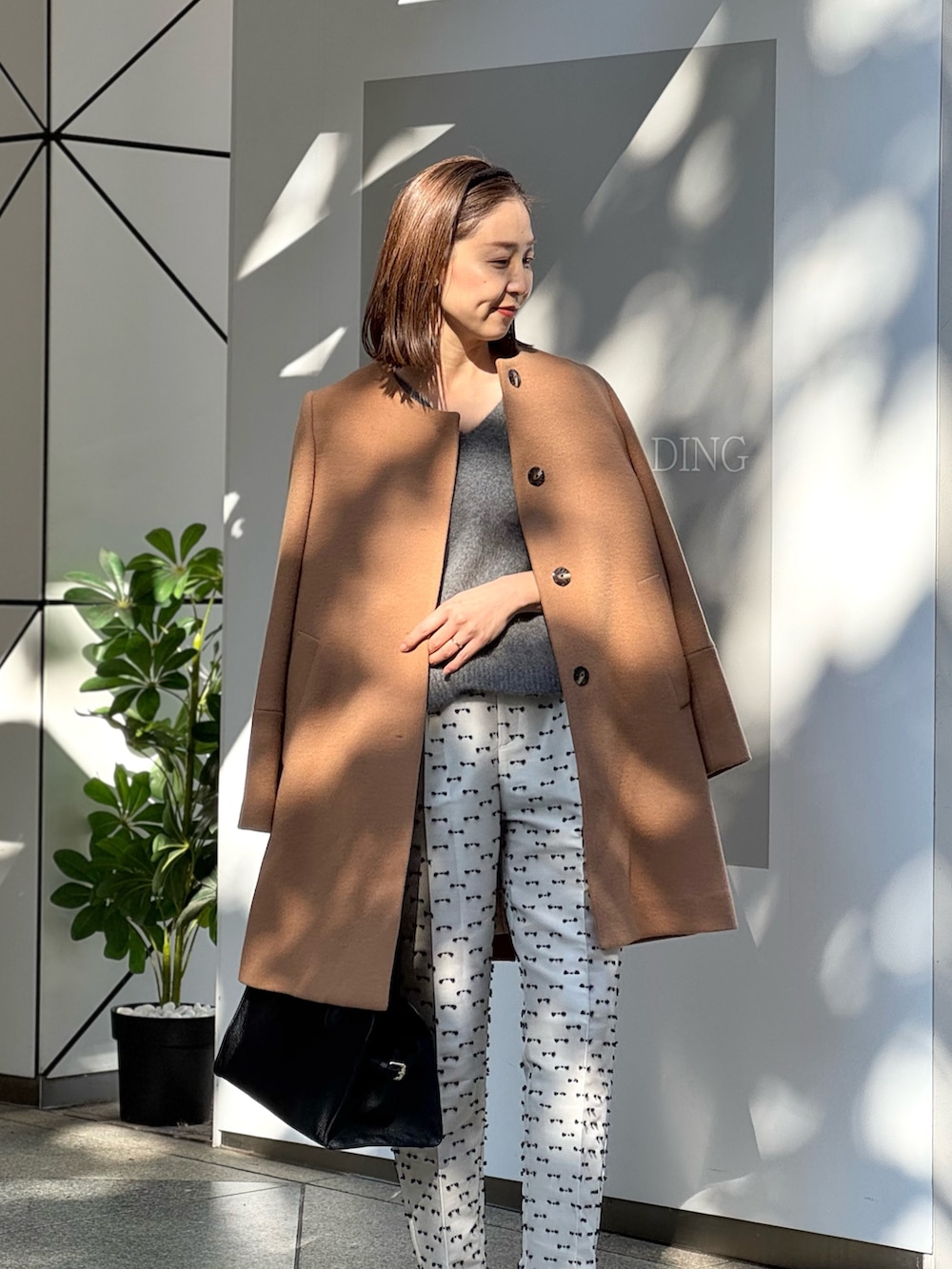 ベージュ系のその他パンツ、ブラック系のパンプス、イエロー系のノーカラーコートを着用したレディースの冬コーディネートの9枚目の写真