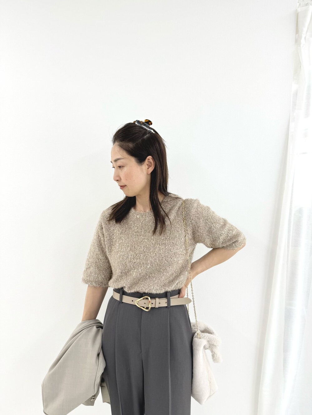 グレー系のその他パンツ、ベージュ系のニット/セーター、ベージュ系のテーラードジャケットを着用したレディースの夏コーディネートの3枚目の写真