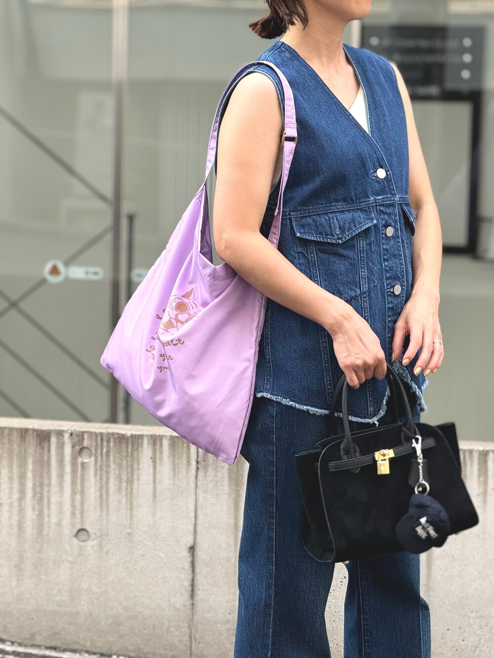 ブルー系のデニムパンツ、ブルー系のベスト、ブラック系のトートバッグを着用したレディースの夏コーディネートの8枚目の写真