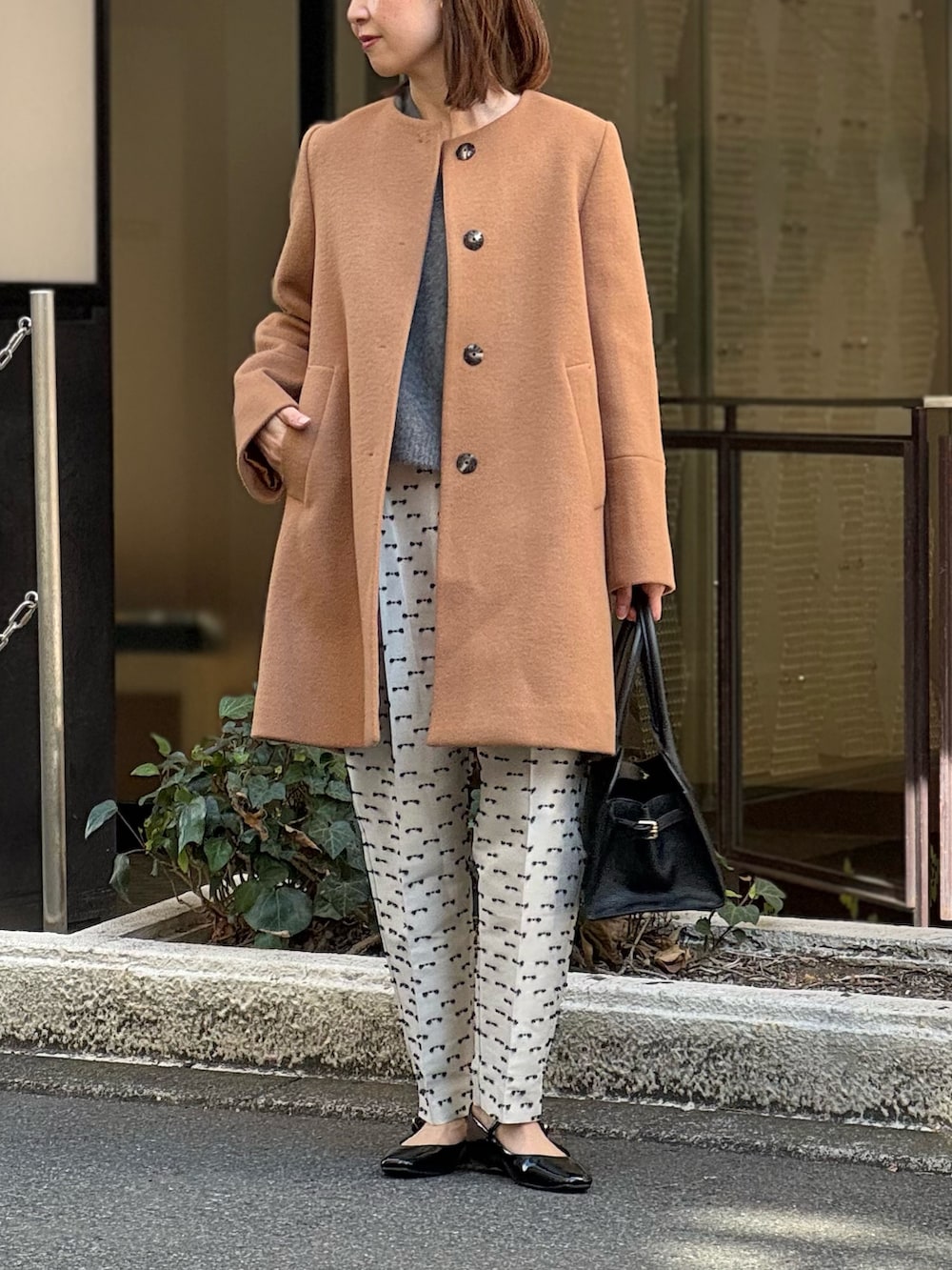 ベージュ系のその他パンツ、ブラック系のパンプス、イエロー系のノーカラーコートを着用したレディースの冬コーディネートの10枚目の写真