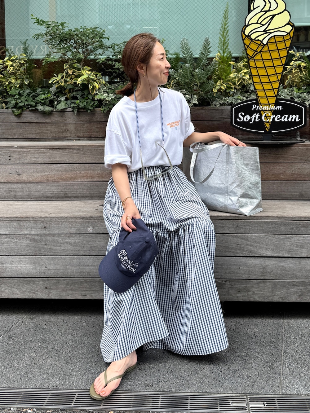 ホワイト系のTシャツ/カットソー、ブルー系のスカート、ブルー系のキャップを着用したレディースの夏コーディネートの2枚目の写真