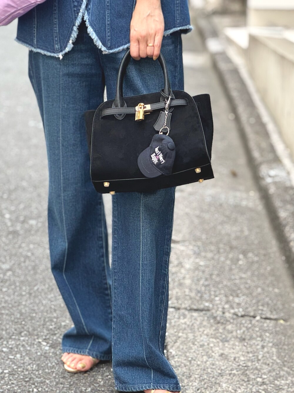 ブルー系のデニムパンツ、ブルー系のベスト、ブラック系のトートバッグを着用したレディースの夏コーディネートの6枚目の写真