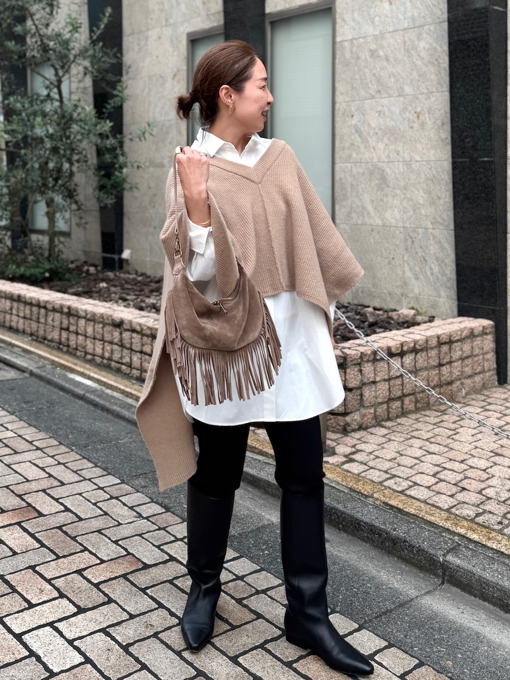 ベージュ系のニット/セーター、ホワイト系のシャツ/ブラウス、ベージュ系のショルダーバッグを着用したレディースの夏コーディネートの2枚目の写真