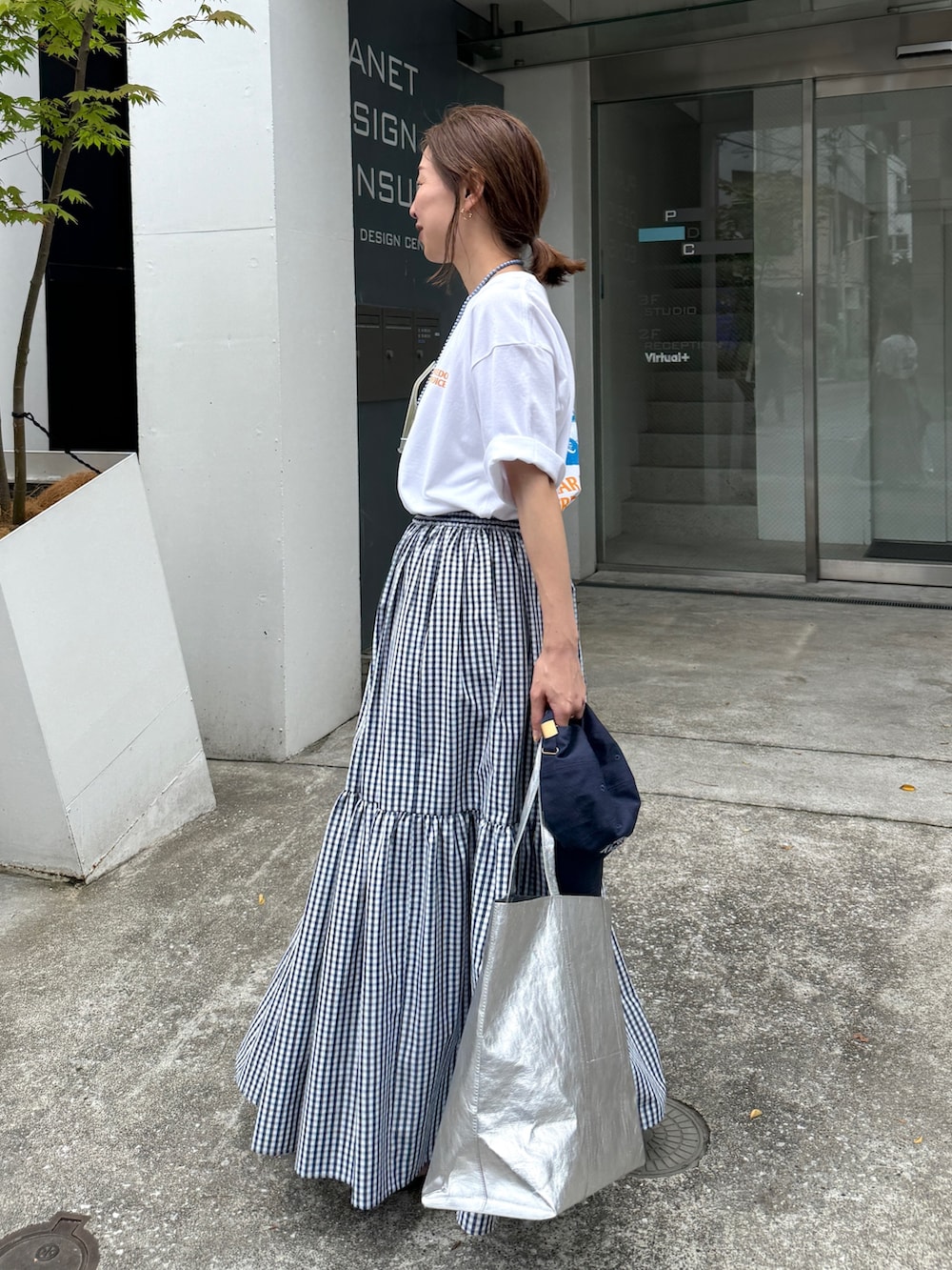 ホワイト系のTシャツ/カットソー、ブルー系のスカート、ブルー系のキャップを着用したレディースの夏コーディネートの6枚目の写真