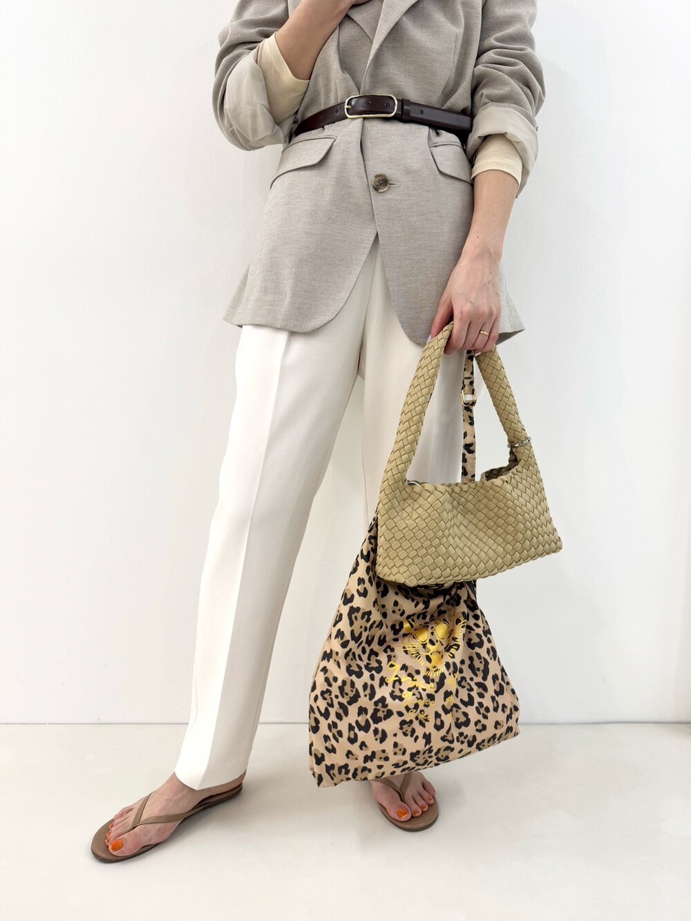 ベージュ系のショルダーバッグ、イエロー系のTシャツ/カットソー、グレー系のテーラードジャケットを着用したレディースの冬コーディネートの6枚目の写真