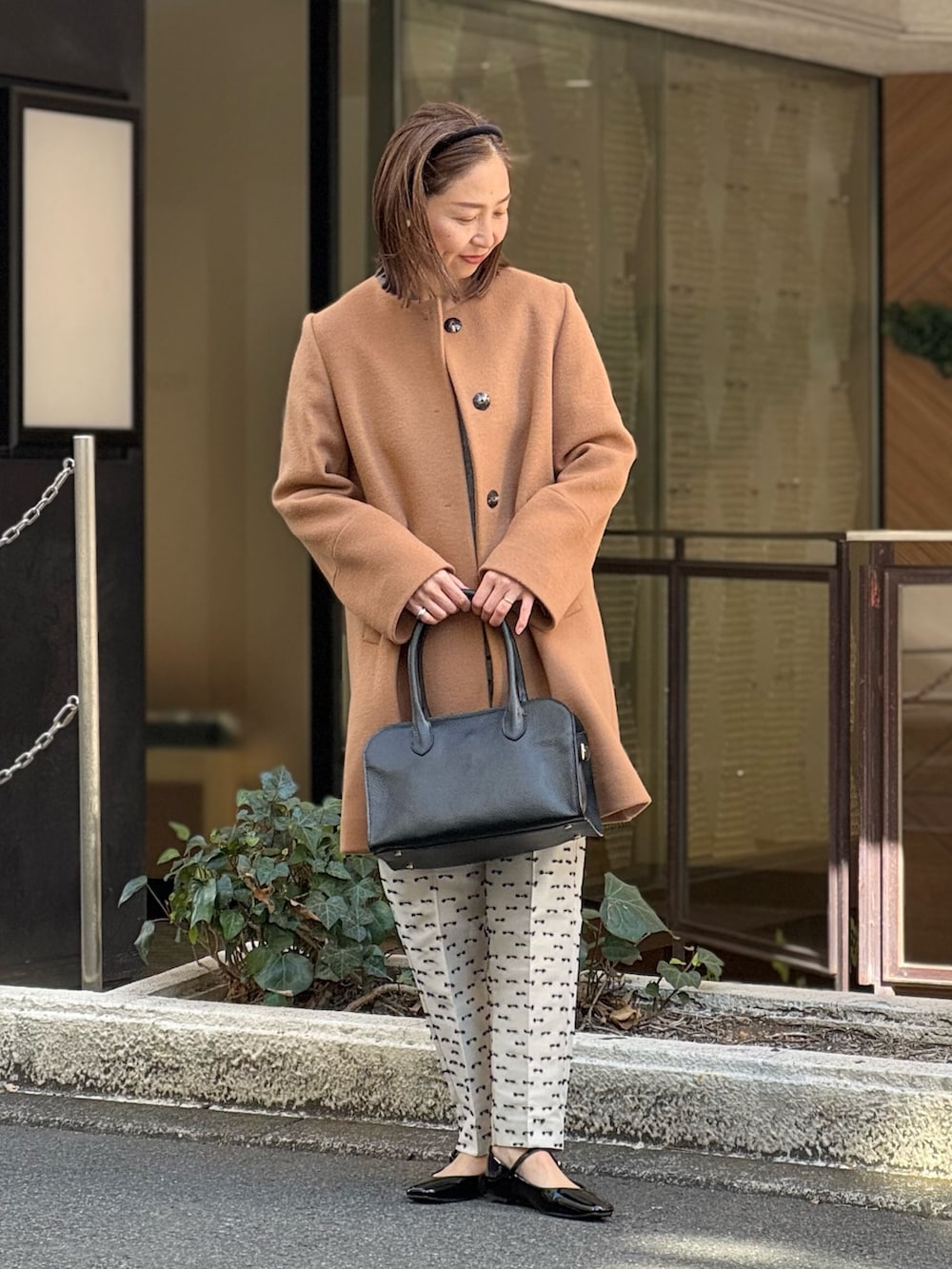 ベージュ系のその他パンツ、ブラック系のパンプス、イエロー系のノーカラーコートを着用したレディースの冬コーディネートの2枚目の写真