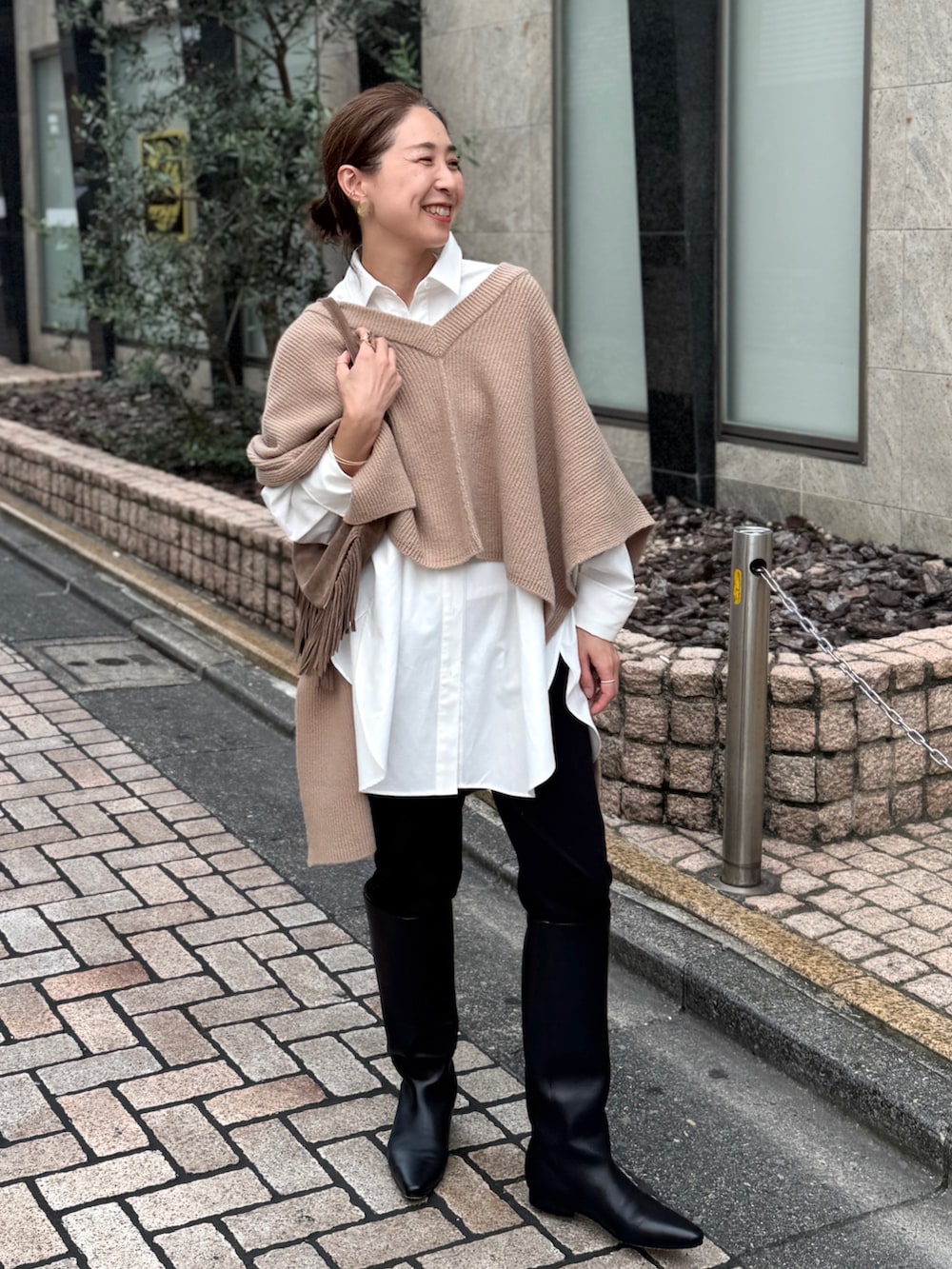 ベージュ系のニット/セーター、ホワイト系のシャツ/ブラウス、ベージュ系のショルダーバッグを着用したレディースの夏コーディネートの3枚目の写真