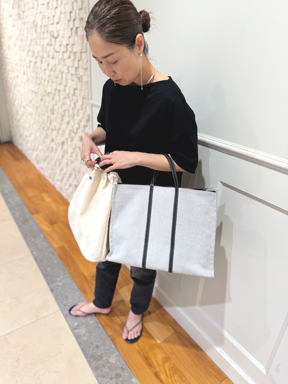 ブラック系のTシャツ/カットソー、ホワイト系のショルダーバッグ、ブラック系のデニムパンツを着用したレディースの夏コーディネートの5枚目の写真