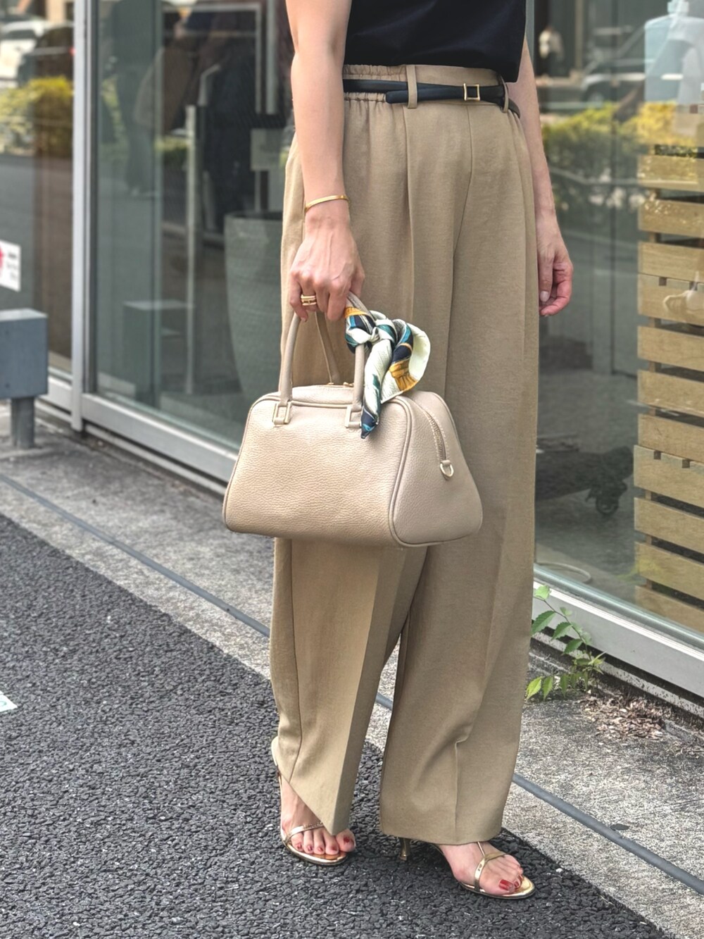 イエロー系のその他パンツ、ブラック系のTシャツ/カットソー、ベージュ系のショルダーバッグを着用したレディースの夏コーディネートの3枚目の写真