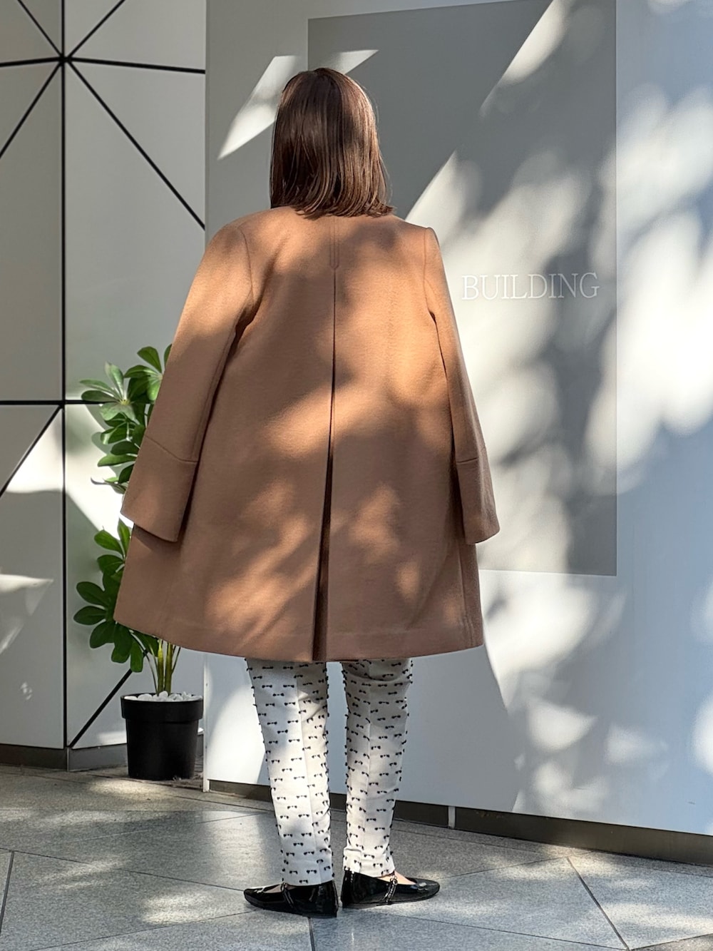 ベージュ系のその他パンツ、ブラック系のパンプス、イエロー系のノーカラーコートを着用したレディースの冬コーディネートの8枚目の写真