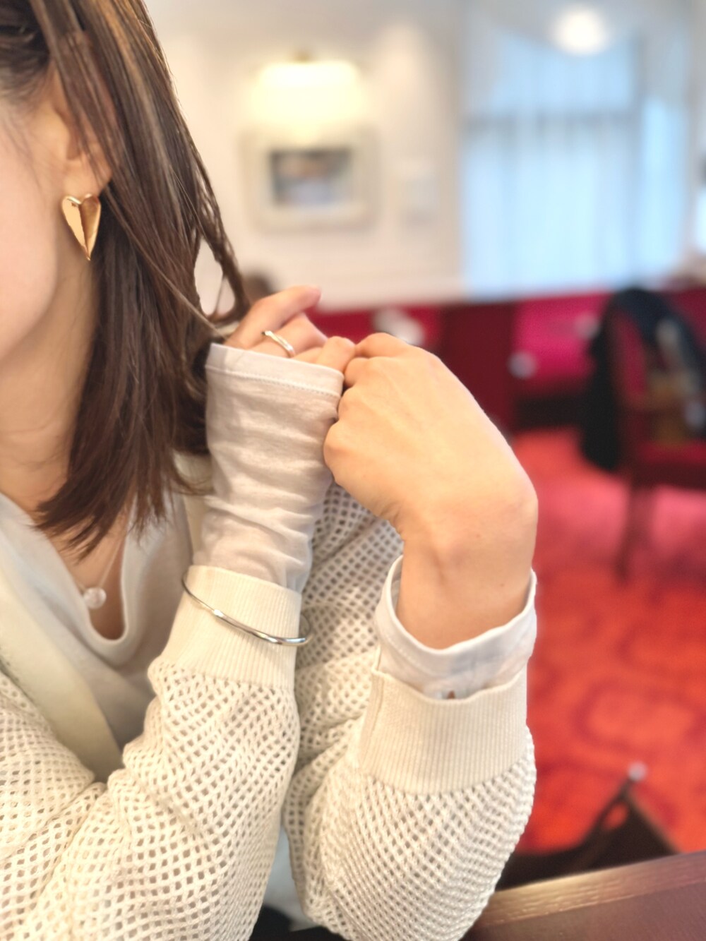 ブルー系のデニムパンツ、ブラウン系のショルダーバッグ、ホワイト系のカーディガン/ボレロを着用したレディースの春コーディネートの8枚目の写真