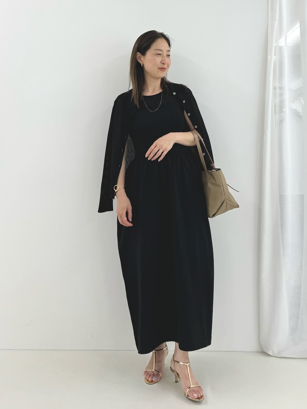 ブラック系のワンピース、ベージュ系のトートバッグ、ブラック系のカーディガン/ボレロを着用したレディースの夏コーディネートの4枚目の写真